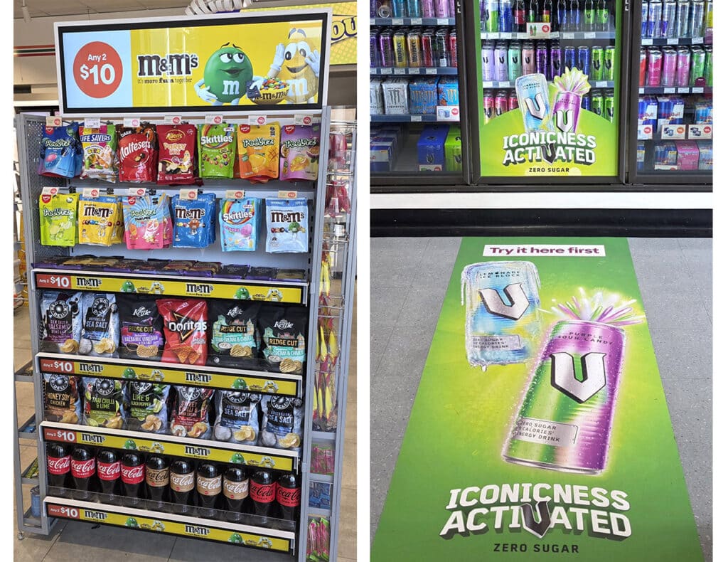 Confectionery display with an advertising screen alongside energy-drink advertising on a refrigerator and shop floor.