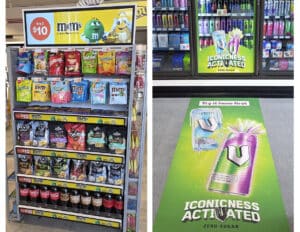Confectionery display with an advertising screen alongside energy-drink advertising on a refrigerator and shop floor.