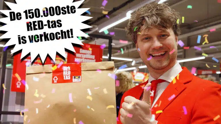Man in a red suit beside a Dirk RED bag, with confetti and Dutch text marking 150,000 bags sold.