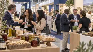 Grocery buyers discussing food samples with exhibitors at a professional trade fair
