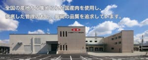 JA Zen-Noh Meat Foods factory exterior beneath a blue sky, with Japanese text across the top.