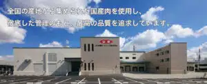 JA Zen-Noh Meat Foods factory exterior beneath a blue sky, with Japanese text across the top.