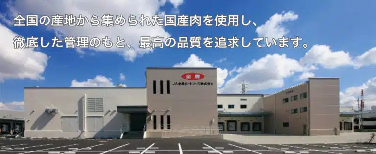 JA Zen-Noh Meat Foods factory exterior beneath a blue sky, with Japanese text across the top.