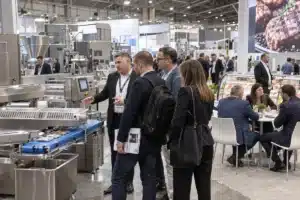 Buyers viewing meat-processing equipment at a trade show