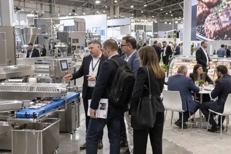 Buyers viewing meat-processing equipment at a trade show