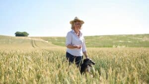 Claire Donkin standing with a dog in a wheat field at Donkin Farm
