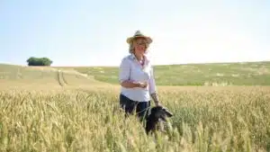 Claire Donkin standing with a dog in a wheat field at Donkin Farm