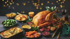 Roast turkey with potatoes, Brussels sprouts, carrots and gravy on a festive table