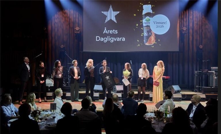 People stand on stage beneath a screen showing Arla Protein Chocolate Milk Drink as the 2026 winner.