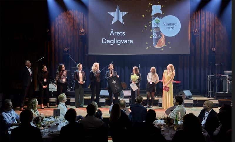 People stand on stage beneath a screen showing Arla Protein Chocolate Milk Drink as the 2026 winner.