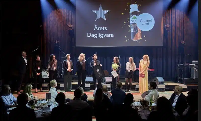 People stand on stage beneath a screen showing Arla Protein Chocolate Milk Drink as the 2026 winner.