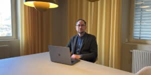 Martin Knutson seated at a table with an open laptop