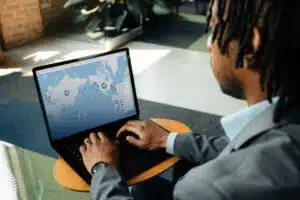 A person using a laptop displaying C.H. Robinson's Navisphere logistics map