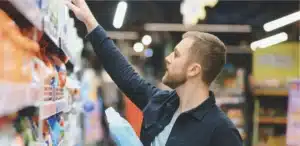 Shopper choosing a bottle of washing liquid