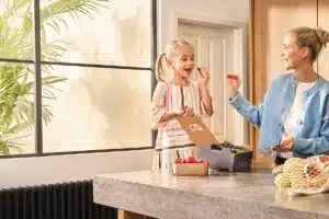 Woman and girl eating food in a kitchen
