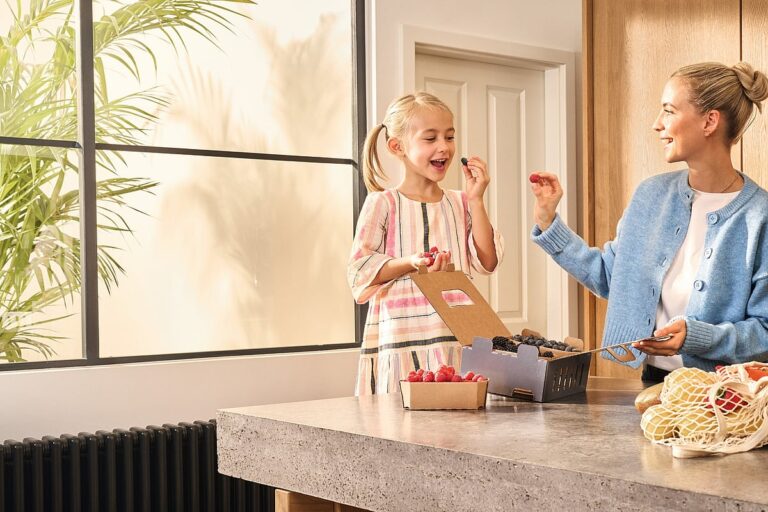 Woman and girl eating food in a kitchen