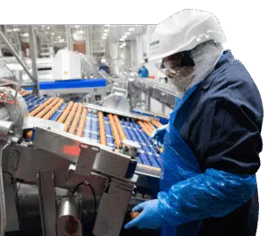 Employee inspecting sausage production at Smithfield Foods
