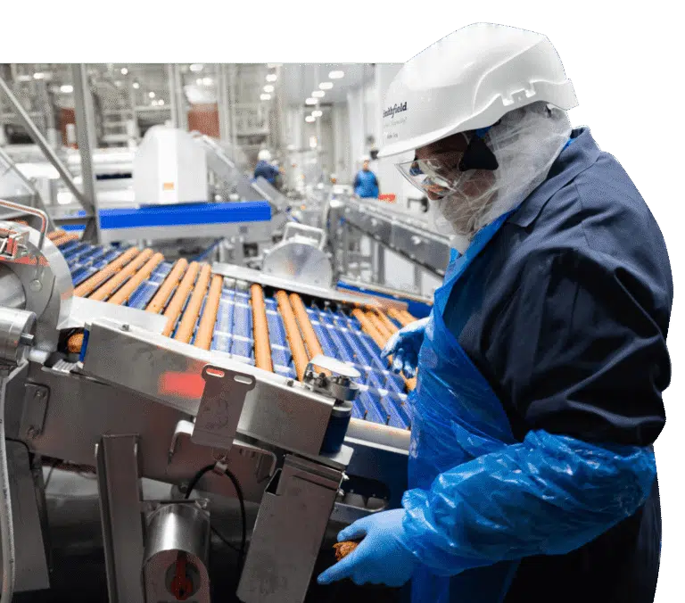 Employee inspecting sausage production at Smithfield Foods