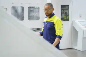 Smurfit Westrock machine operator wearing safety glasses and a yellow and navy uniform