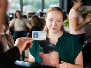 A member of staff scans a driving licence while a customer waits at a counter