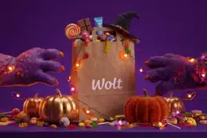 Wolt delivery bag beside pumpkins and packaged sweets